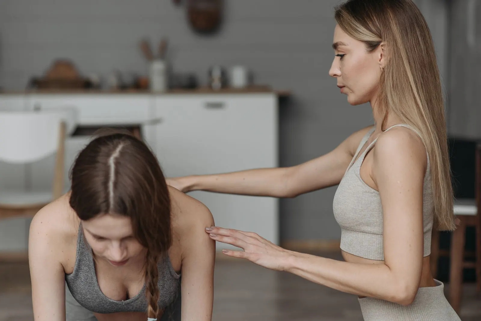 A trainer guides a client through an exercise in the client’s home